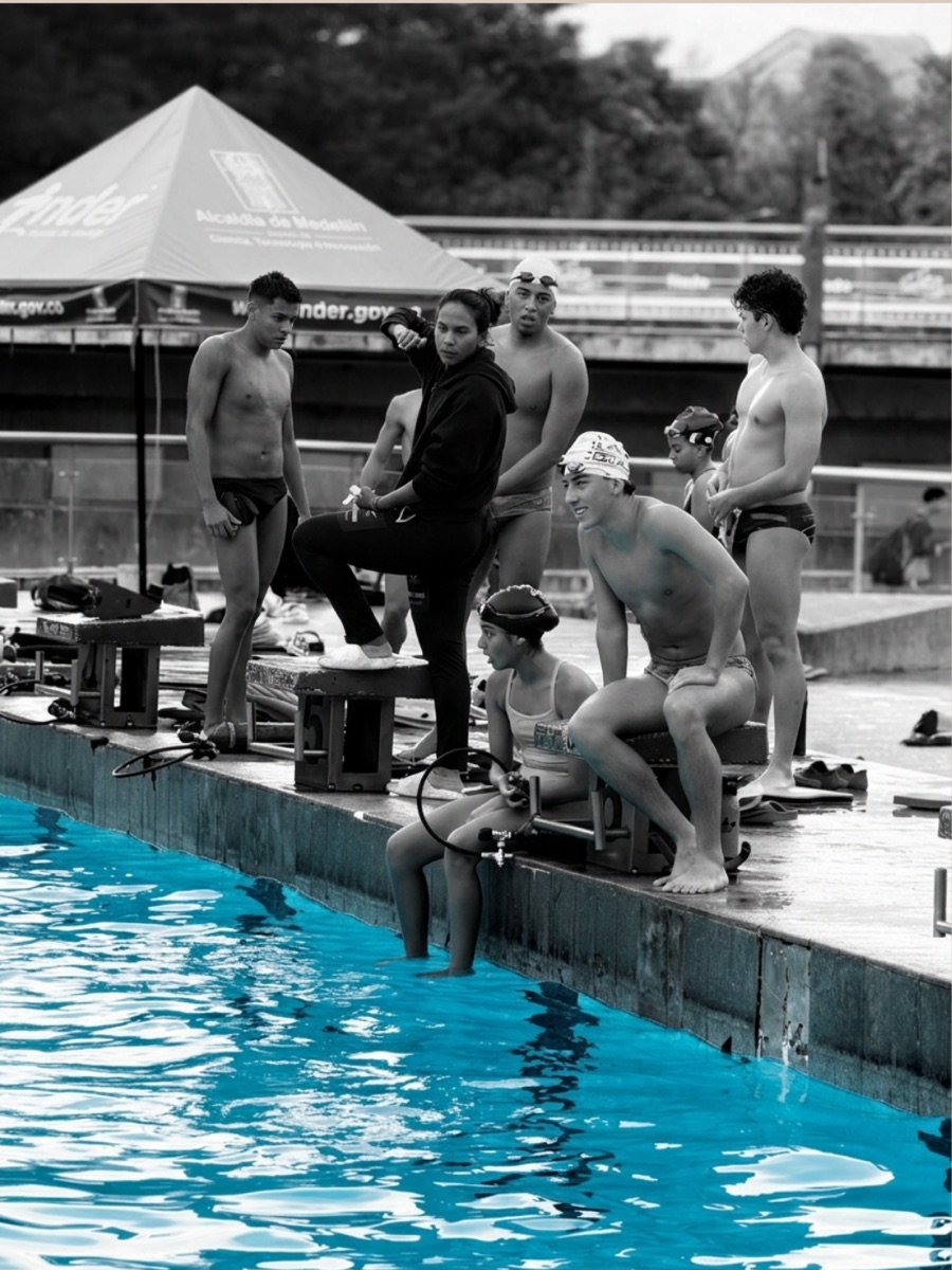 Grupo de deportistas de monoaleta reunido en el borde de la piscina antes de entrenar